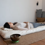 installation de sound healing avec futon de soin et bol chantant pour séance de bain sonore et relaxation holistique