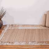 Tapis de yoga en soie brute et jute déplié sur un sol intérieur, utilisé comme tapis de méditation ou base de protection pour futon