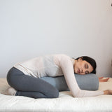 posture de yoga restorative avec yoga bolster de soutien en lin gris