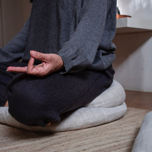 Image d'une femme méditant sur un coussin zafu dans un studio zen à Casablanca
