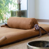 Bolster en lin terracotta posé sur son futon et rembourré au kapok 