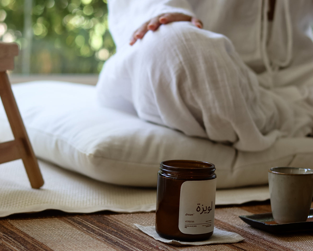 femme assise en tailleurs dans son coin de méditation zafu et zabuton en lin et bougie naturelle fait au maroc
