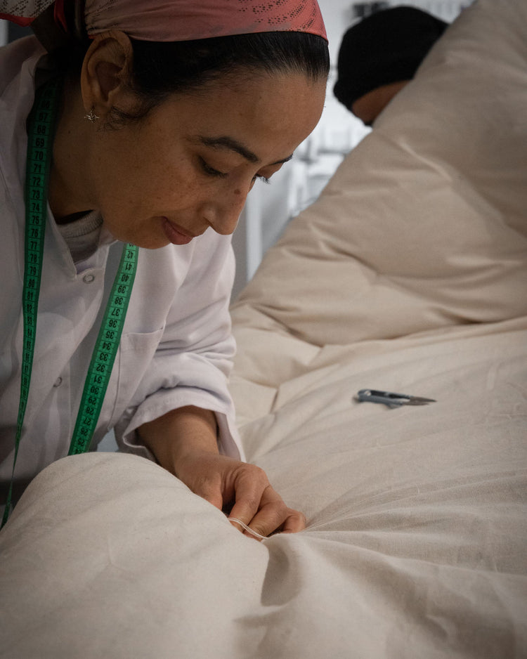 Dans les coulisses de l'atelier cocon, couturiére surpiquant un futon de yoga rembourré au kapok naturel 